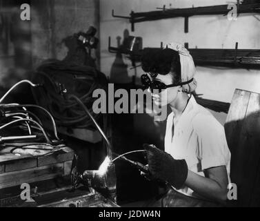 A female welder working in the prefabrication shop in K-25 uranium enrichment plant February 1944 in Oak Ridge,  Tennessee. Oak Ridge was the site of the Clinton Engineer Works where the Manhattan Project to make an atomic bomb was based during WWII. The facility relied on women workers as the majority of men were serving in the military during the war. Stock Photo