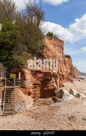 Warning signs beside the unstable cliffs at Sidmouth, which frequently fracture and fall onto the beach below. Stock Photo