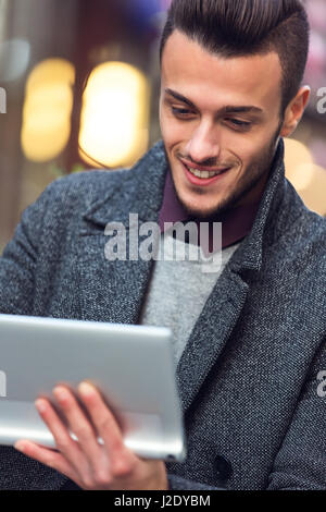 Handsome young man using modern digital tablet. Toned photo Stock Photo