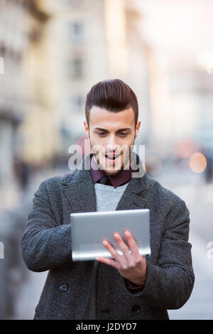 Handsome young man using modern digital tablet. Toned photo Stock Photo