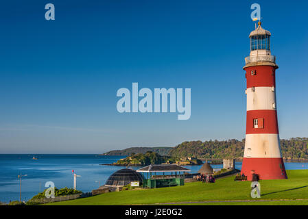 People enjoy the early morning sunshine near Smeatons Tower on Plymouth Hoe in south Devon. Stock Photo