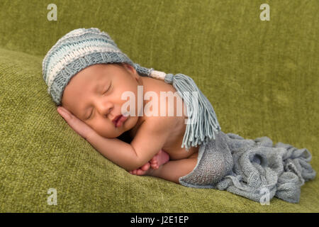 Adorable African newborn baby of 7 days old sleeping on a green blanket Stock Photo