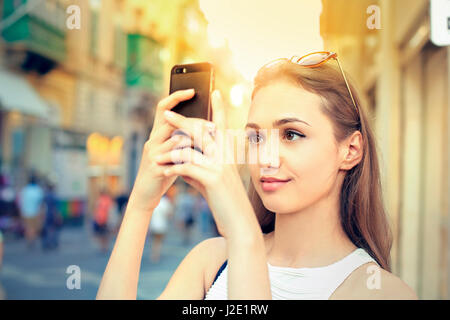 Pretty woman taking photo with phone Stock Photo