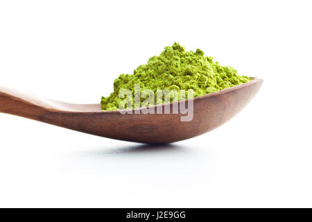 Green matcha tea powder in wooden spoon isolated on white bakground. Stock Photo