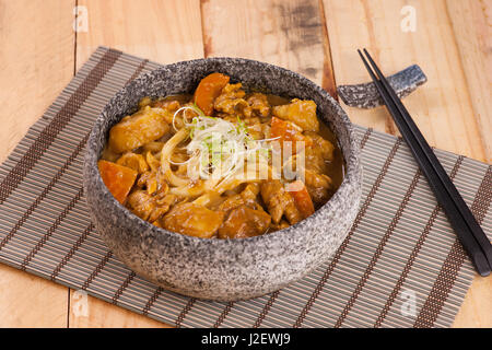 Korean stone bowl of beef noodle with onion on bamboo tray Stock Photo