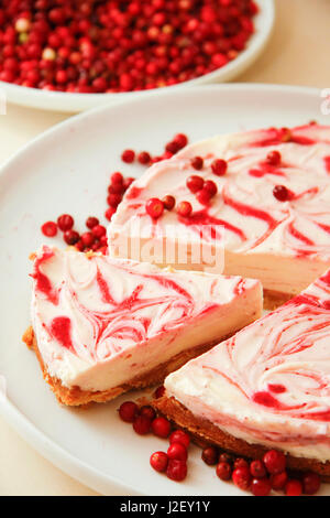 Cheese cake with cream and rasberry on white platter Stock Photo