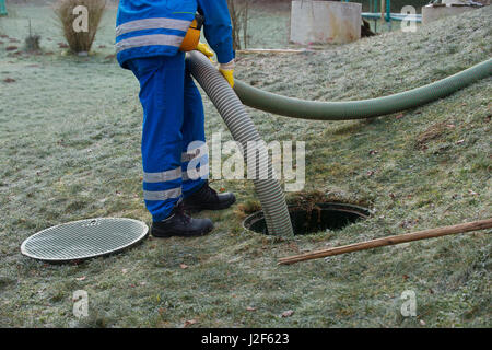 Emptying household septic tank. Cleaning sludge from septic system. Stock Photo