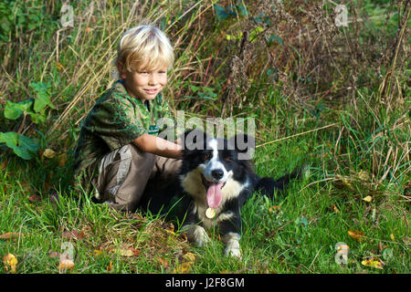 Blond boy with Border Collie Stock Photo