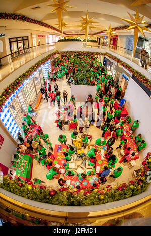 Multiracial Christmas celebrants, many in period costumes, throng a annual holiday festival at a luxury shopping mall in Costa Mesa, CA. Note craft fair in foreground. Stock Photo