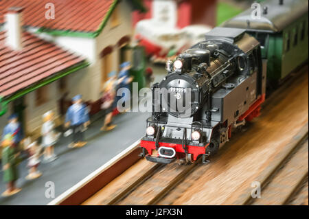 model railroad steam locomotive (with fake number) speeding through a station Stock Photo