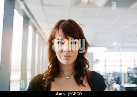 Close up portrait of beautiful mature businesswoman standing in office. Caucasian female corporate professional looking at camera. Stock Photo