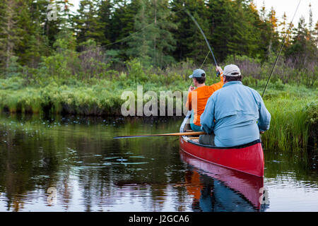 Two men fly-fishing for brook trout from a canoe on the Cold Stream 'deadwater' above Upper Cold Stream Falls in Maine's Northern Forest. Johnson Mountain Township. (MR) Stock Photo