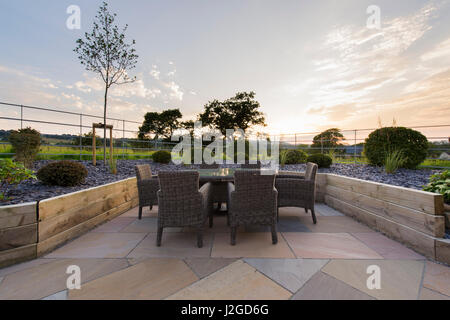 Beautiful, private, contemporary landscaped, garden, Yorkshire, England, UK - outdoor seating (patio furniture) by raised border & topiary shrubs. Stock Photo