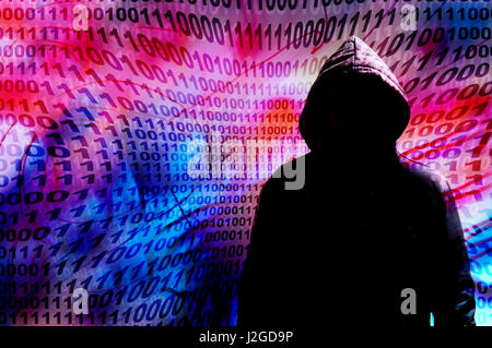 mysterious hacker in hood against a background of binary digits Stock Photo