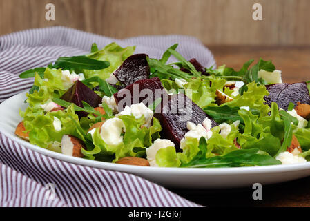 Salad vinaigrette with beets, lettuce, arugula, feta, and almonds, Stock Photo