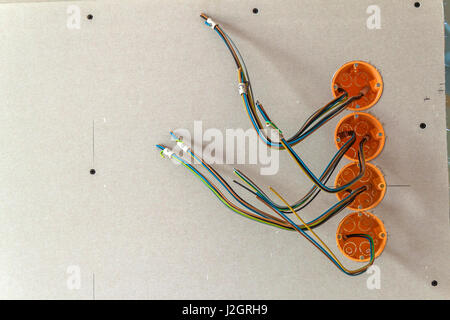 New electrical installation, socket plastic boxes and electrical cables on the wall, renovation concept. Electrical wiring installation. Stock Photo