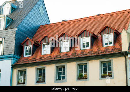 Roofs of old houses with roof windows and orange roof tiles in German city Stock Photo
