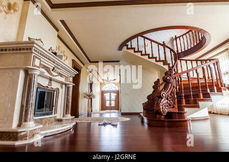 Modern architecture interior with classic elegant luxury hallway with curved glossy wooden staps stairs in modern storey house Stock Photo