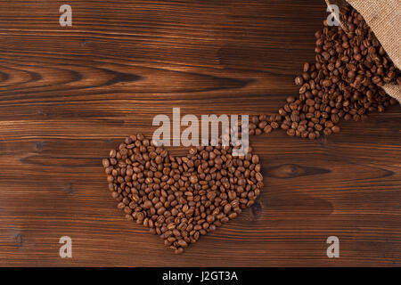 lettering coffee. Coffee beans in the form of a heart coffee, wooden background Stock Photo