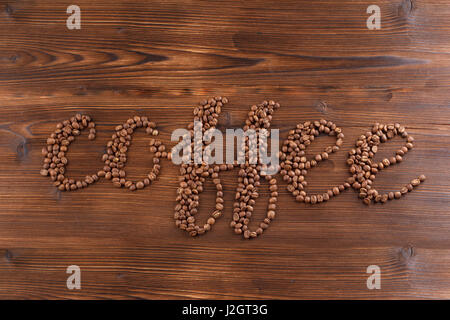 lettering coffee. Coffee beans in the form of a text coffee, wooden background Stock Photo