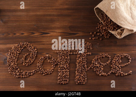 lettering coffee. Coffee beans in the form of a text coffee, wooden background Stock Photo