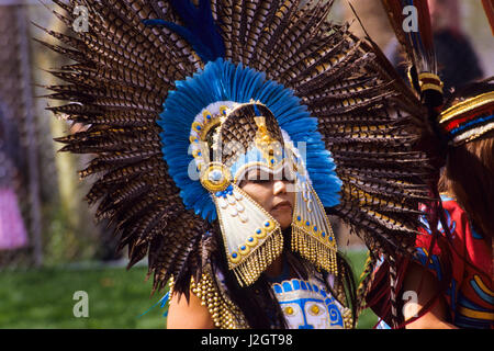 Aztec woman wears a magnificent traditional golden headdress made with blue stones and blue exotic bird feathers Stock Photo