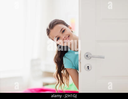 happy smiling beautiful girl behind door at home Stock Photo