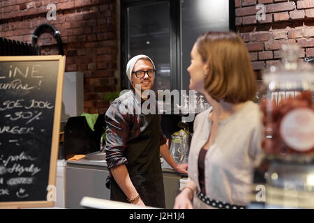 happy bartenders at cafe or coffee shop counter Stock Photo