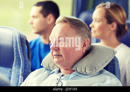 senior man sleeping in travel bus with neck pillow Stock Photo