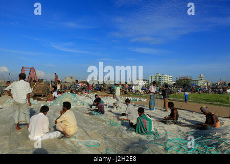 Fishermen mending their fishing nets at Fisheryghat in Chittagong, Bangladesh. Stock Photo