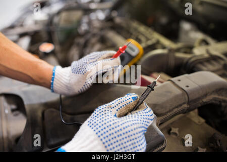 auto mechanic man with multimeter testing battery Stock Photo
