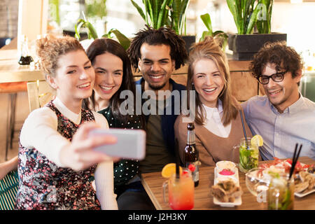friends taking selfie by smartphone at bar or cafe Stock Photo
