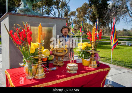 An elderly Vietnamese American is proud of his shrine at the statue of Tran Hung Dao (1226-1300), Supreme Commander of Vietnam during the Tran Dynasty in a Lunar New Year or Tet celebration in a Fountain Valley, CA, park. Stock Photo