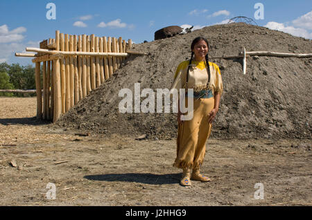 Women of the Mandan, Hidatsa and Arikara built permanent earthen lodges that formed large communities along the Missouri River. A woman presenter in traditional dress explains at the re-constructed Indian village on the Fort Berthold Reservation, ND Stock Photo