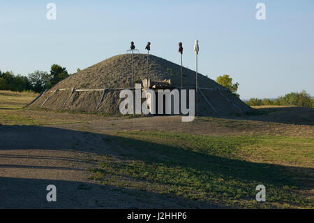 Reconstructed medicine lodge with traditional sacred medicine bundles stuffed with corn on mounted onto poles placed at the entrance at On-A-Slant Indian Village, South Dakota Stock Photo