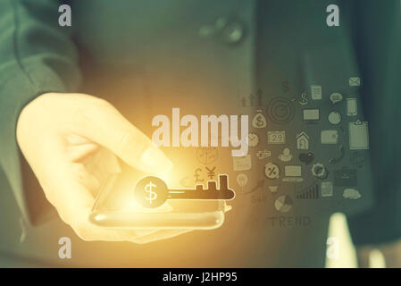 Computer applications icons against close up view of businesswoman using her smart phone. Business technology and E-commerce concept. Stock Photo