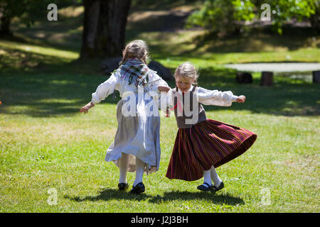 RIGA, LATVIA - 12 JUN 2016: Latvian dancers - small girls in national costumes. Cultural event in Latvian Ethnographic Museum. Stock Photo