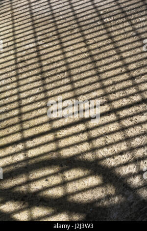 Abstract shadow of metal grille on concrete floor surface. Stock Photo