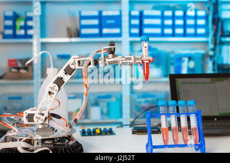 Robotic arm holding test tube in the laboratory. Stock Photo
