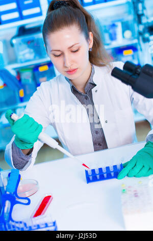 Female scientist using pipette in the laboratory. Stock Photo