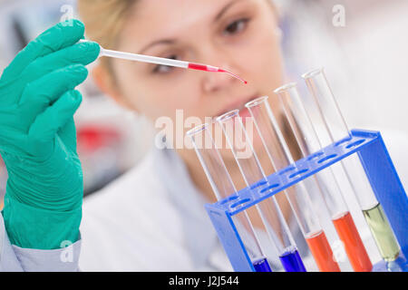 Female scientist using pipette in the laboratory. Stock Photo