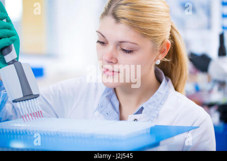 Female scientist using multi pipette in the laboratory. Stock Photo