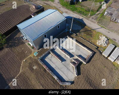 Buildings on the site. Hangar from metal profile, corrugated. The foundation of the house Stock Photo