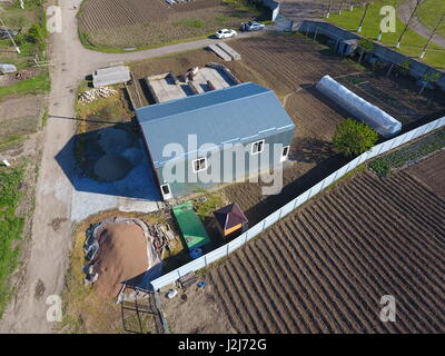 Buildings on the site. Hangar from metal profile, corrugated. The foundation of the house Stock Photo