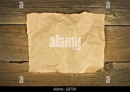Blank crumbled brown paper on a rustic wooden background Stock Photo