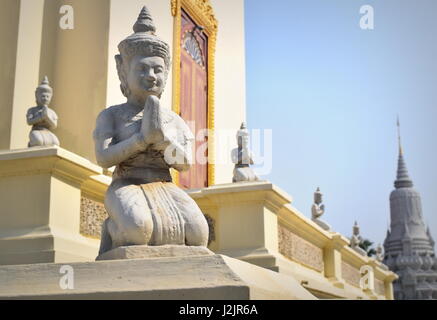 Line up of praying Buddha statues kneeling with hands together, at Silver pagoda section of Phnom Penh Royal palace by a royal stupa - Cambodia Stock Photo