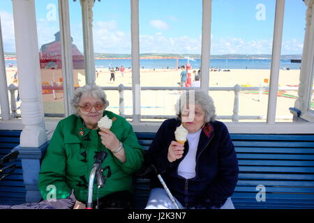 Weymouth, Dorset, UK. 29th Apr, 2017. Two Weymouth resisents enjoy an icecream by the beach and make the best or a cool and breezy day with occasional spells of sunshine at Weymouth as the weather is set to deteriorate tomorrow with rain moving into the area. Credit: Tom Corban/Alamy Live News Stock Photo