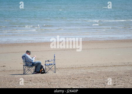 Weymouth, Dorset, UK. 29th Apr, 2017. A Beach goers finds some solitude on Wetmoutg beach and makes the best or a cool and breezy day with occasional spells of sunshine at Weymouth as the weather is set to deteriorate tomorrow with rain moving into the area. Credit: Tom Corban/Alamy Live News Stock Photo