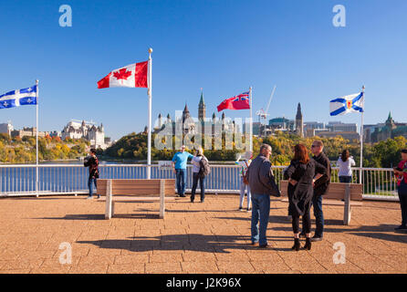 Parliament Hill in Ottawa, Ontario with tourists in the foreground as seen from Hull, Gatineau, Quebec, Canada. Stock Photo