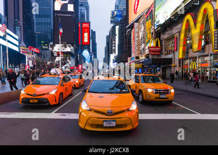 Yellow Taxi Cabs Lined Up Waiting At Stop Sign In Early Evening Light, Times Square, New York Stock Photo